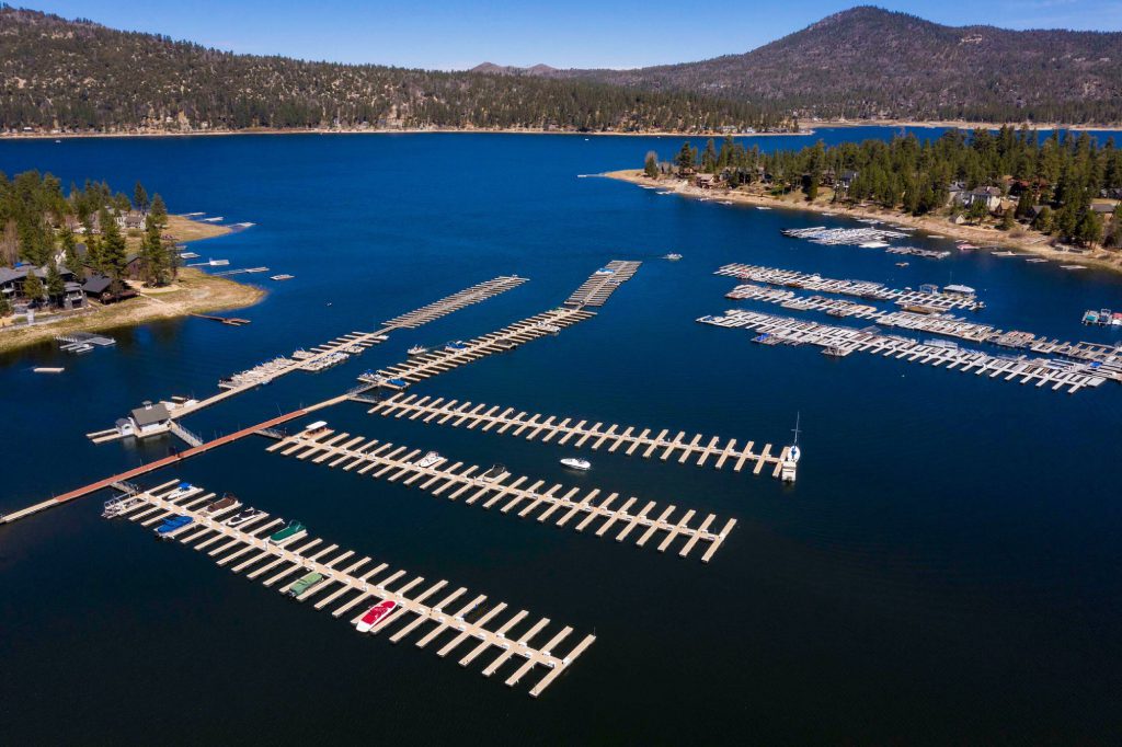 Aerial view of Big Bear Lake marina with docks and mountain shoreline
