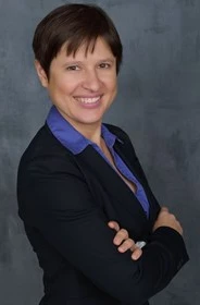 Headshot of Solomiya Pyatkovska in a black business suit with a blue shirt