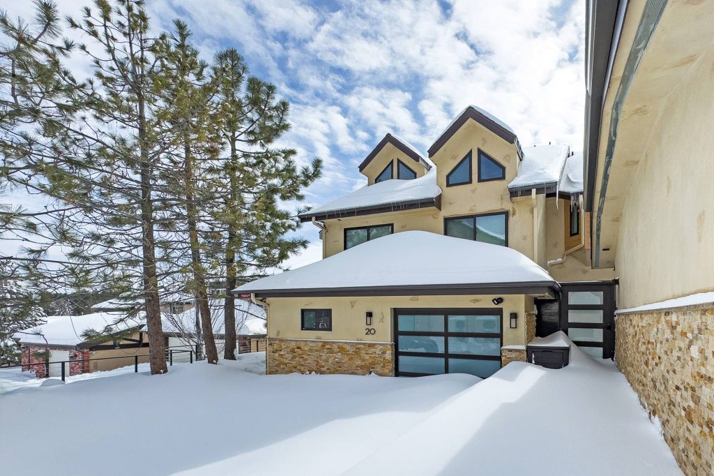 Front view of Comstock Condos in winter with snow-covered roof and garage near Bear Mountain