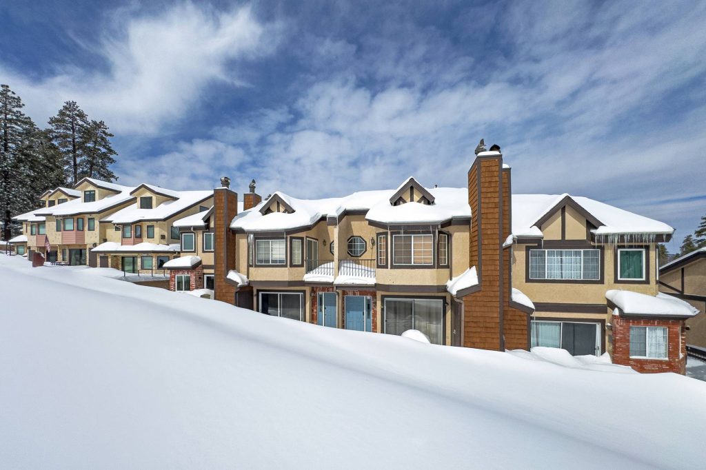 Snow-covered Comstock townhomes exterior with mountain views in Big Bear Lake during winter