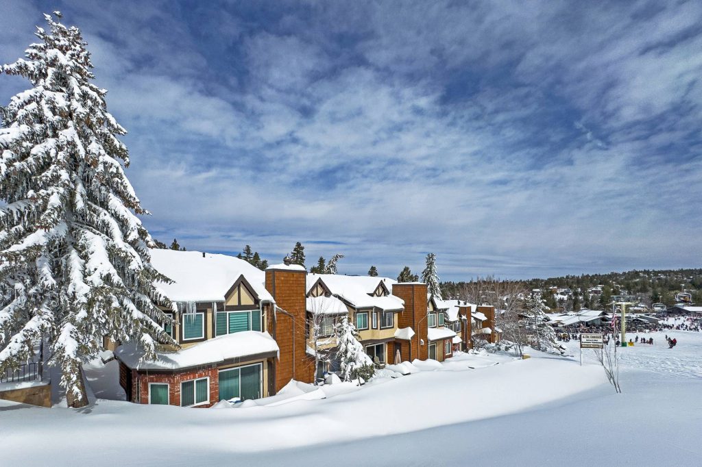 Comstock slopeside condos next to ski area with snowy landscape and pine trees in Big Bear Lake