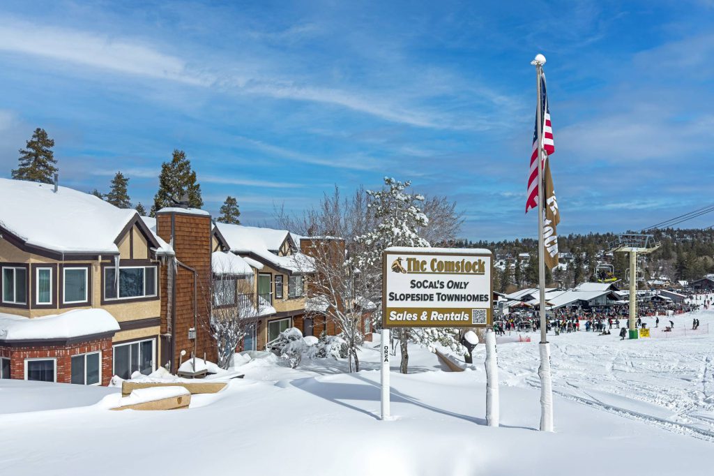 The Comstock slopeside townhomes sign with ski resort and chairlift views in Big Bear Lake