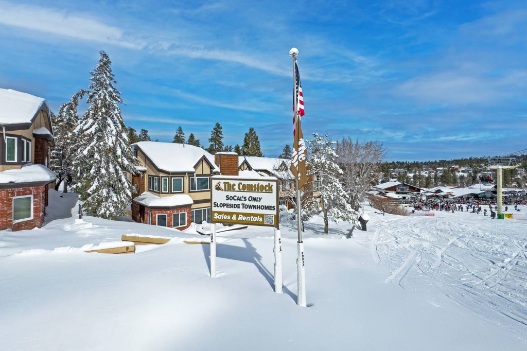 Snowy view of The Comstock townhomes and ski resort area at Big Bear Lake in winter