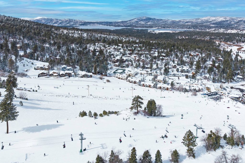 Panoramic winter view of Bear Mountain slopes with Big Bear Lake in distance