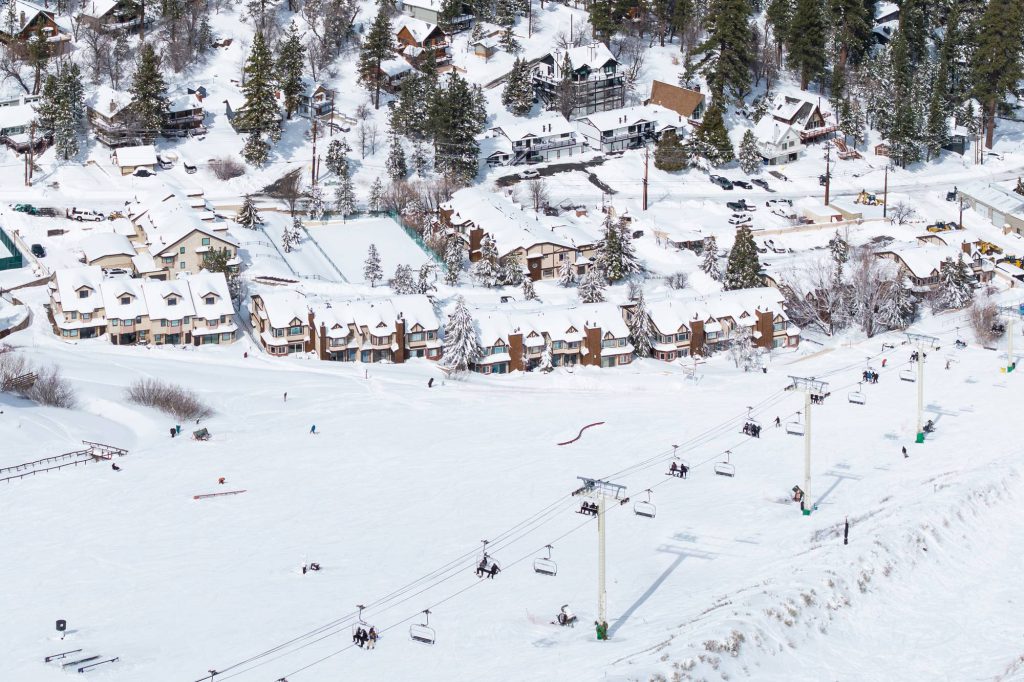 Bear Mountain ski resort base area with snow-covered village and parking