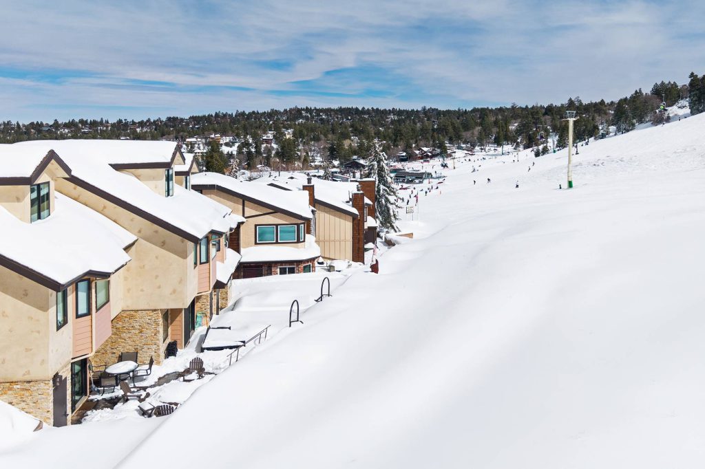 Snow-covered Comstock Highlands condos directly beside Bear Mountain ski slopes