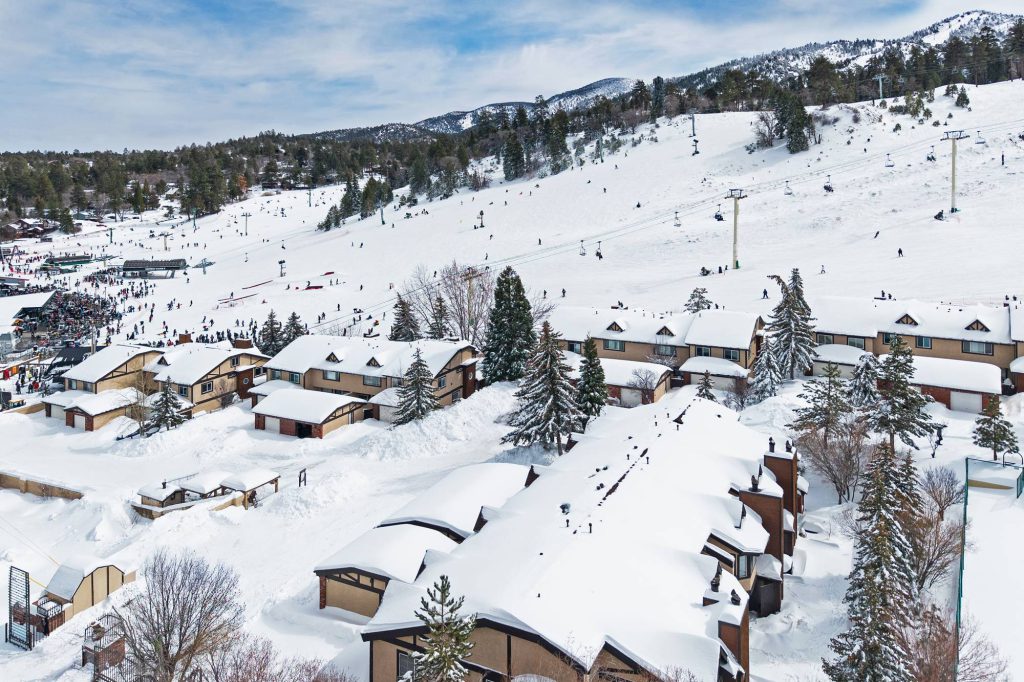 Chairlift rising above Bear Mountain slopes behind Comstock Highlands condos