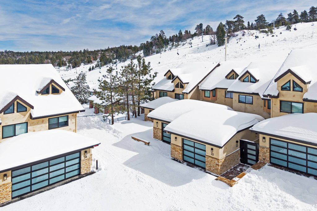 Modern Comstock Highlands condo exterior with snow-covered roof and garages