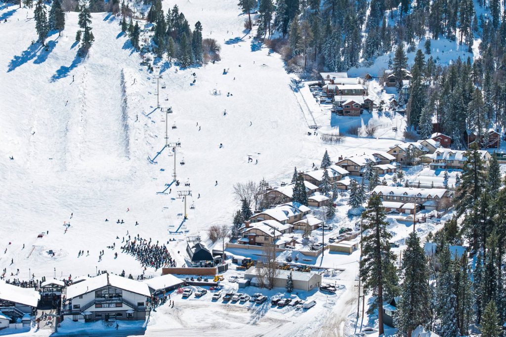 Close aerial of Bear Mountain ski lift and base buildings in winter