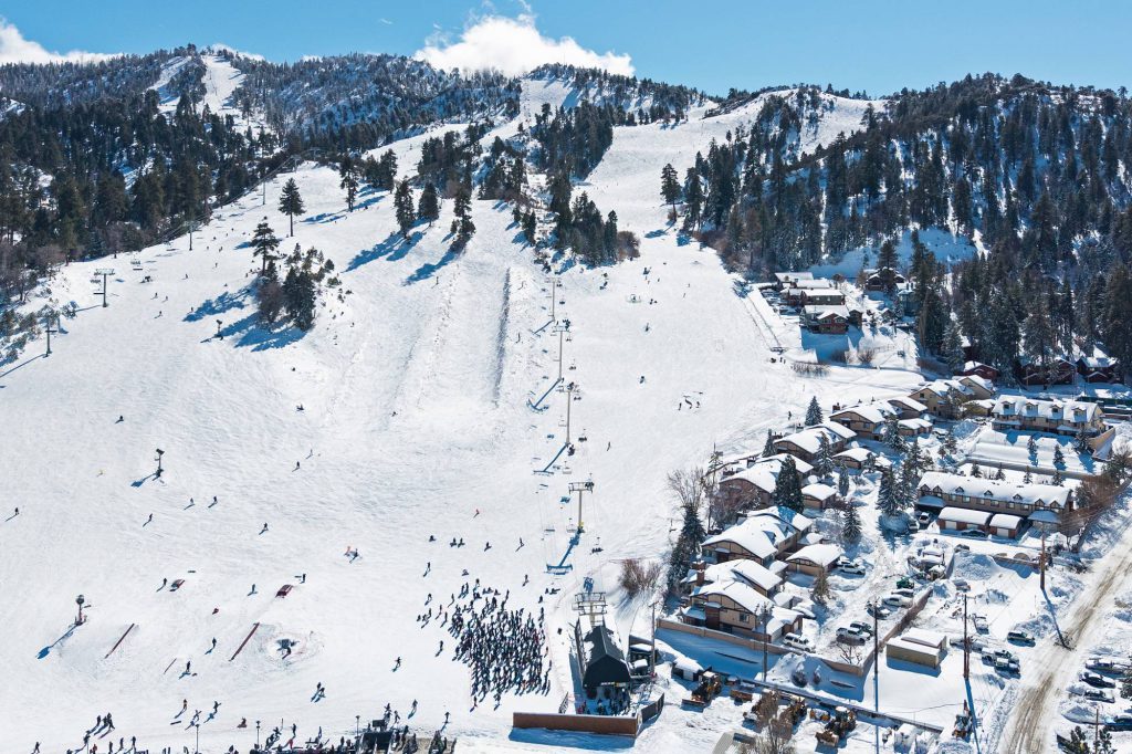 Aerial view of Bear Mountain ski slopes and chairlift with Comstock Highlands condos below in winter