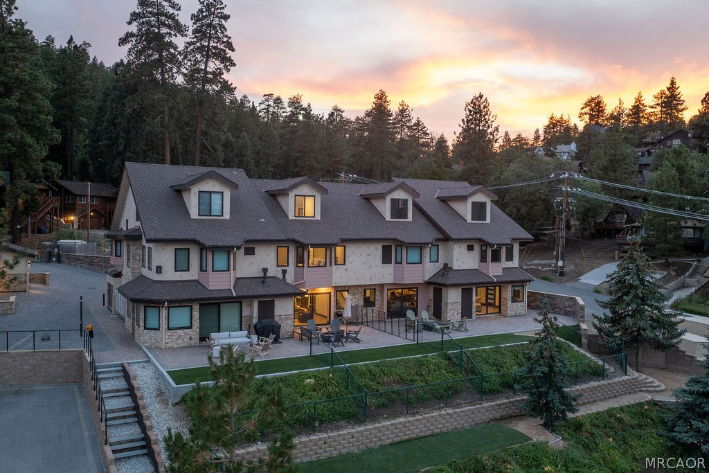 Luxury mountain cabin surrounded by pine trees during a sunset in Big Bear